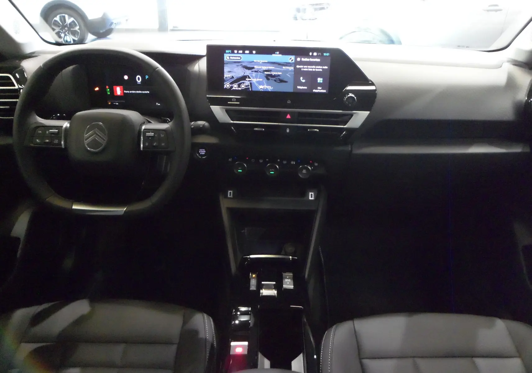 Intérieur de la Citroën C4 Hybride 136 e-DCS6 Max 2025, vue du tableau de bord avec écran tactile et volant noir.