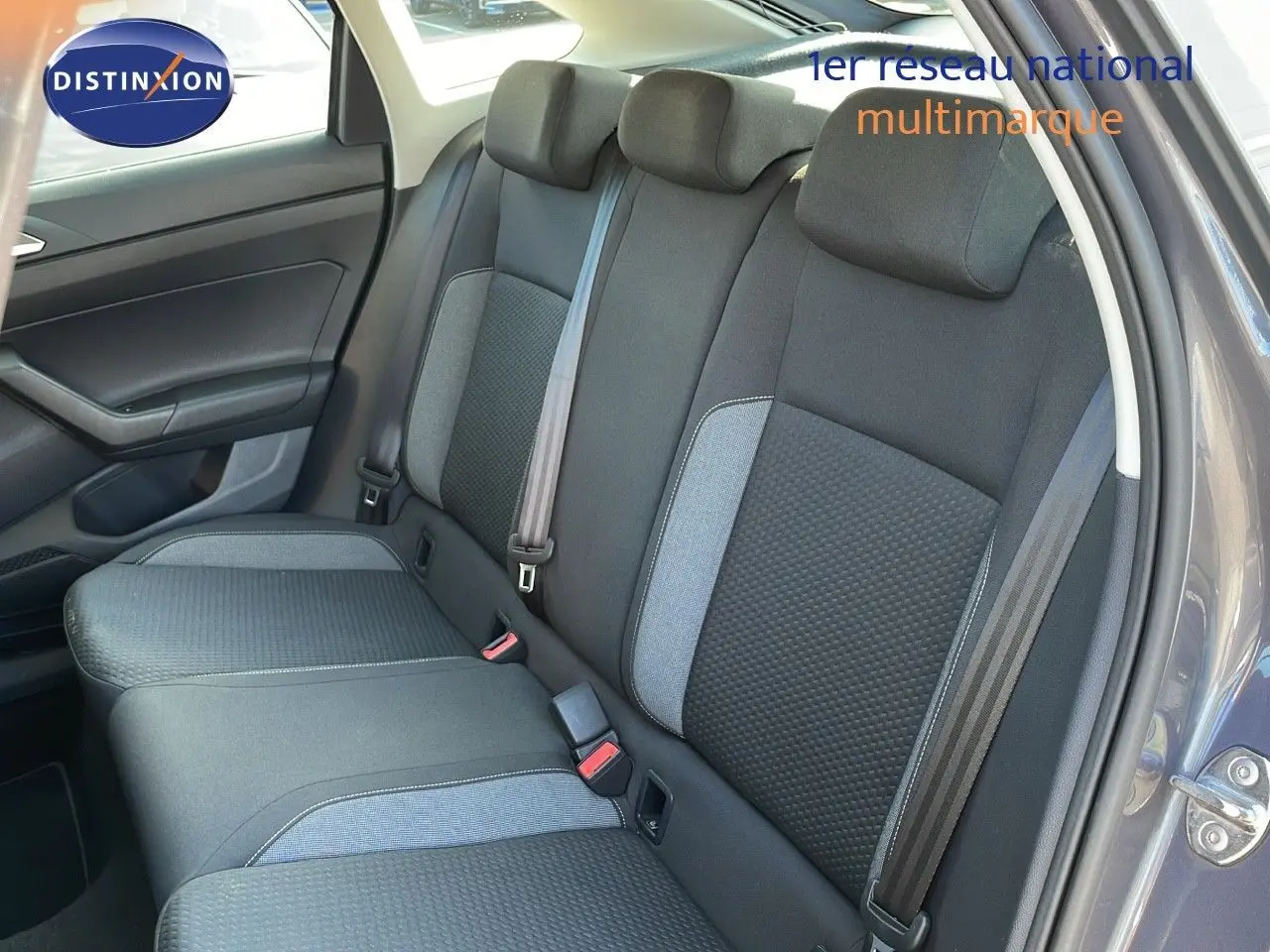 Vue intérieure du siège arrière côté droit du Volkswagen Taigo gris cendre avec ceinture de sécurité et garniture tissu noir et gris.