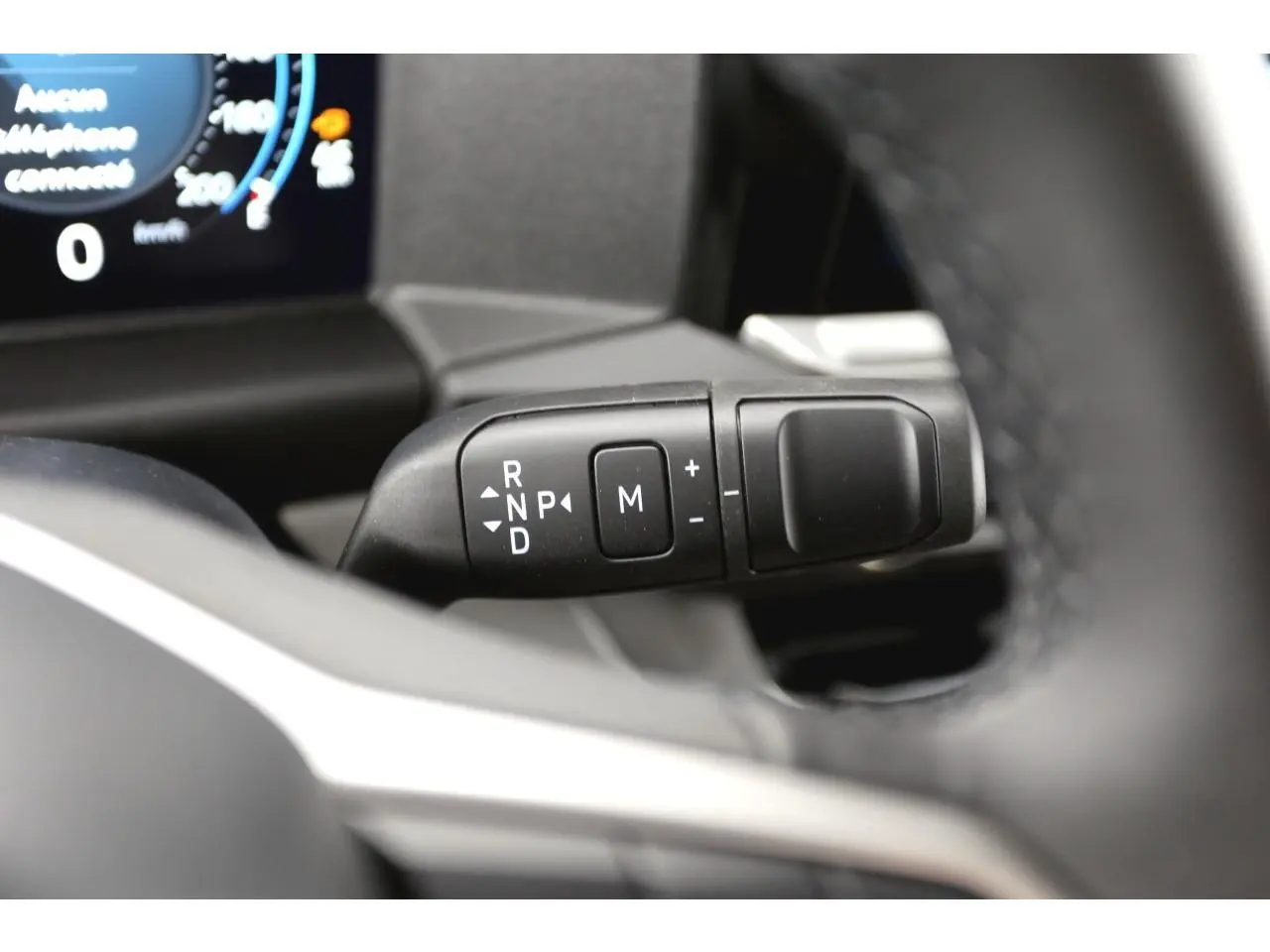 Gros plan sur la commande de boîte automatique du Volkswagen Transporter T7, intérieur noir avec écran digital partiel visible.