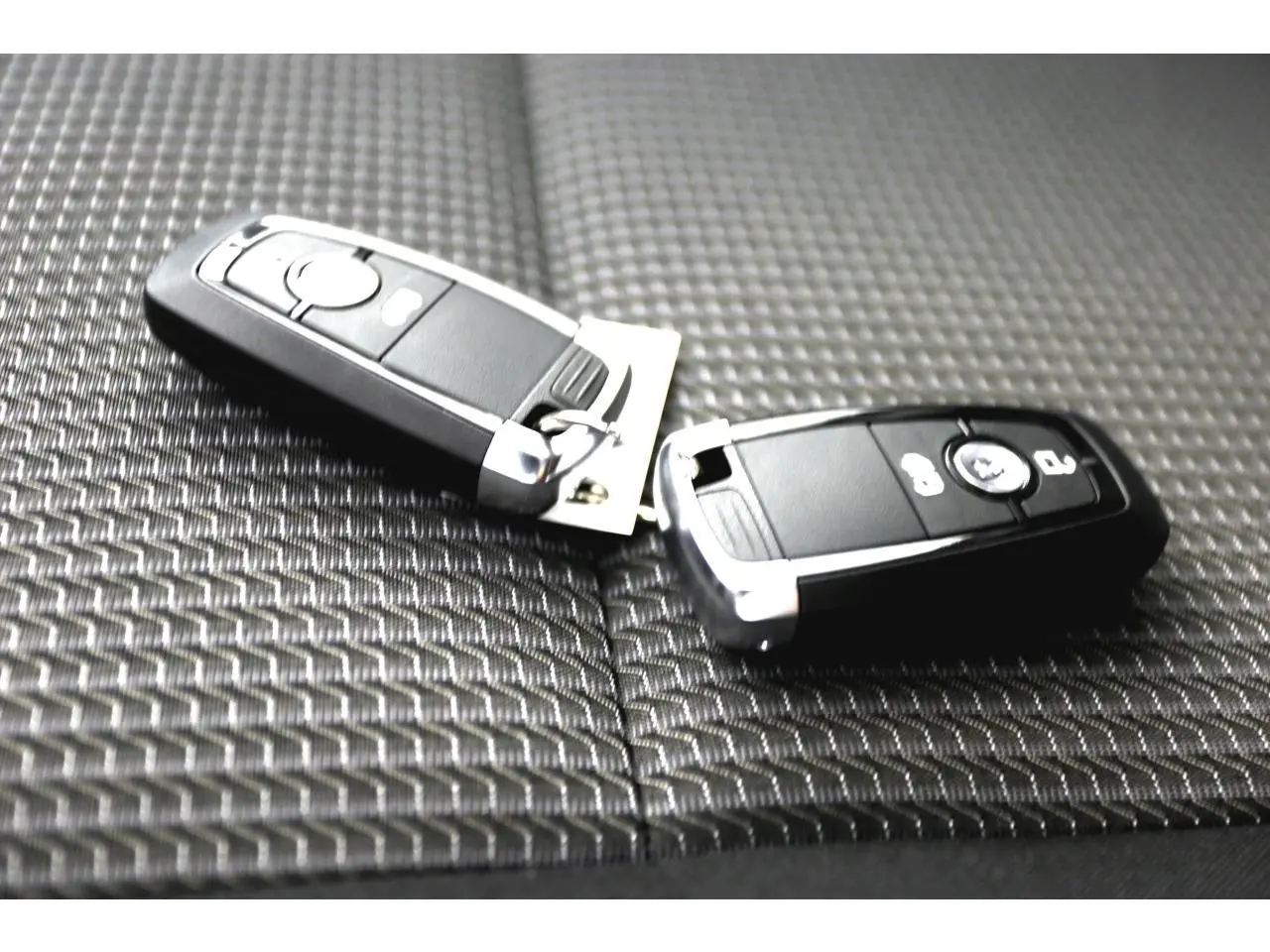 Clé de contact Volkswagen posée sur un siège en tissu à rayures noir du Transporter T7 Business 2025.