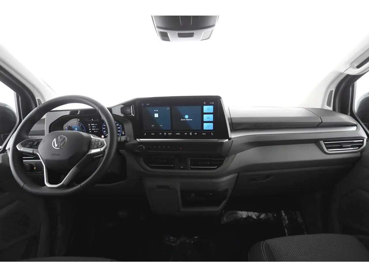 Vue intérieure frontale du Volkswagen Transporter 2025, tableau de bord moderne avec écran tactile 13 pouces et volant multifonction.