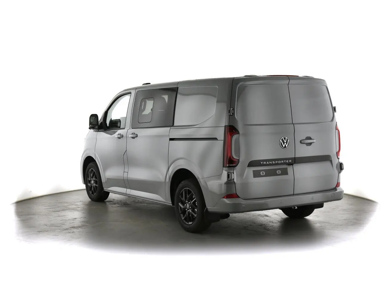Vue 3/4 arrière gauche d'un Volkswagen Transporter gris Stone avec jantes noires et feux arrière LED signature