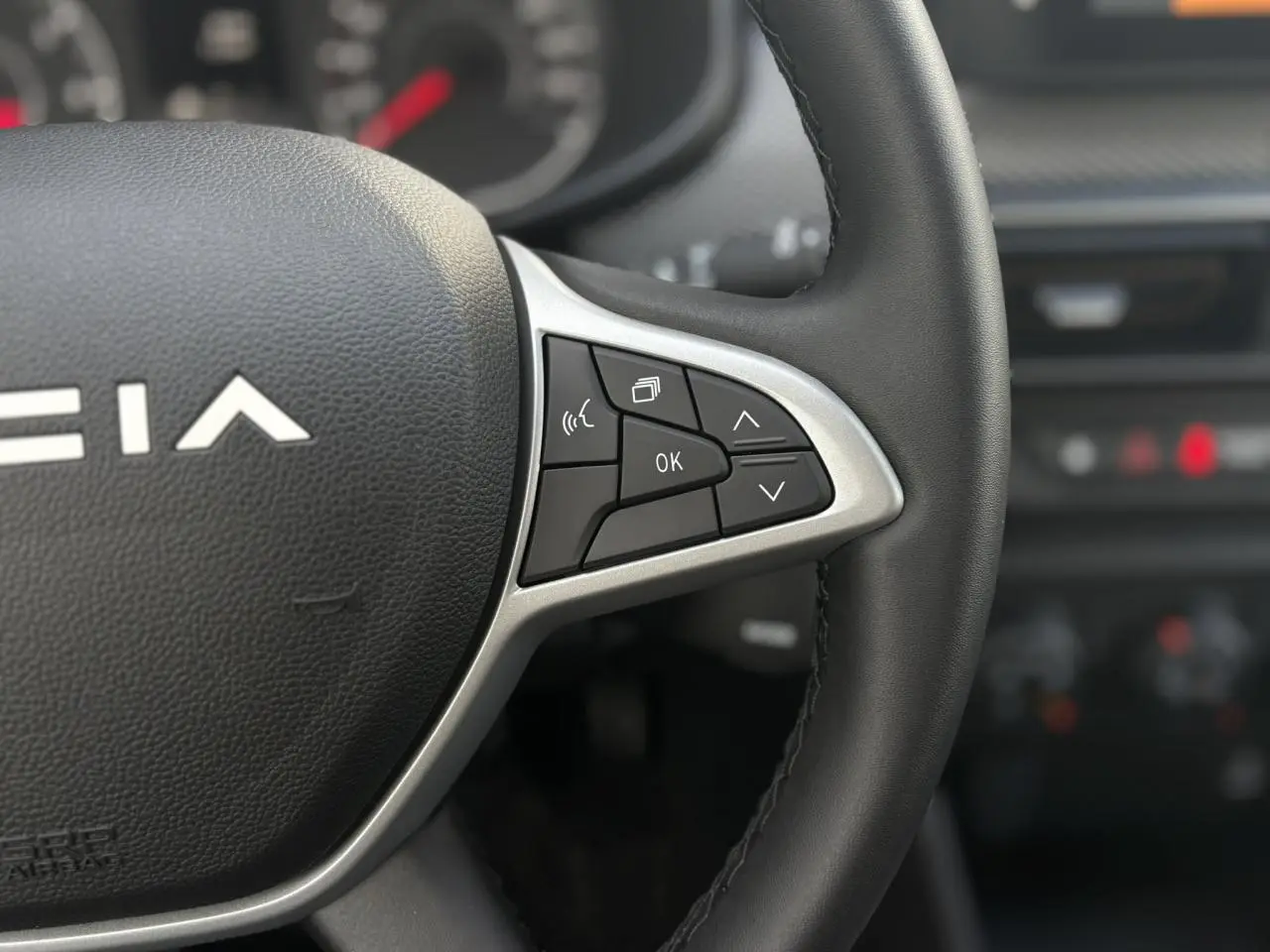 Gros plan sur le volant noir Soft Feel de la Dacia Sandero Stepway 2025 avec commandes multifonctions sur le côté droit.