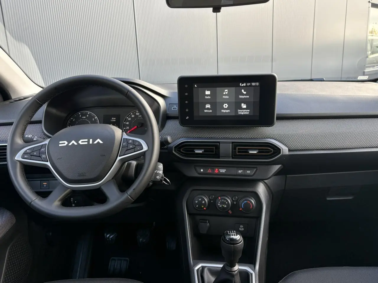 Intérieur de la Dacia Sandero Stepway 2025, vue frontale du tableau de bord avec écran tactile et volant noir.