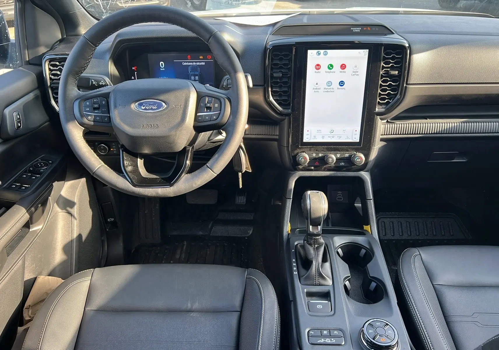 Intérieur du Ford Ranger 2025 vu de face, tableau de bord moderne avec écran tactile vertical et volant multifonction.