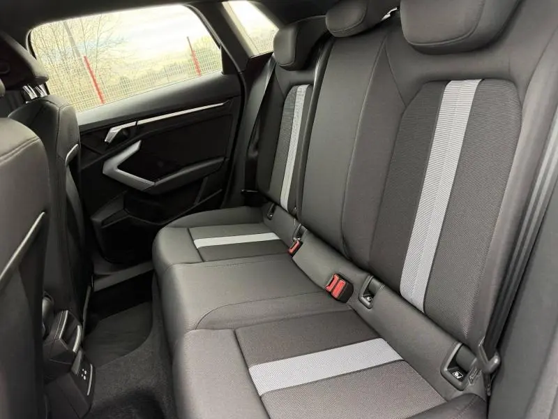Vue intérieure côté droit des sièges arrière en tissu noir avec bandes grises de l'Audi A3 Sportback 2024.