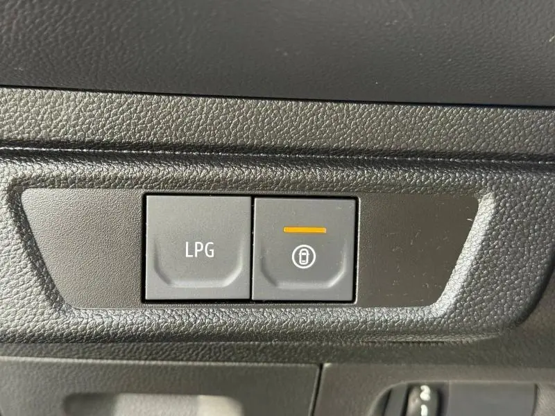 Gros plan sur les boutons LPG et verrouillage centralisé du tableau de bord d’un Dacia Jogger gris Schiste métallisé.