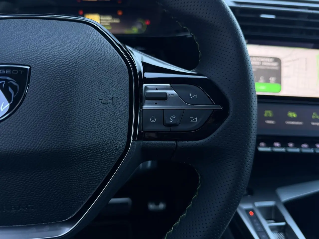Gros plan sur le volant cuir perforé noir avec commandes intégrées du Peugeot 408 Hybrid 145 e-DSC6 GT.