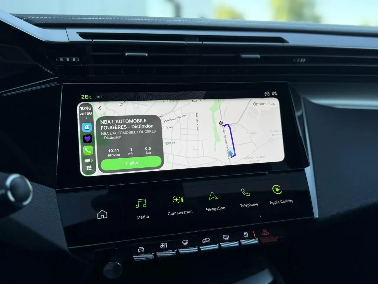 Vue rapprochée de l’écran tactile central du Peugeot 408 blanc Okenite affichant la navigation et les commandes multimédia.