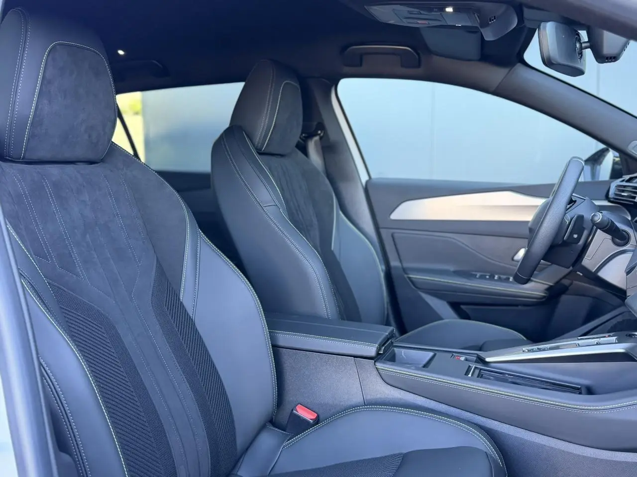 Intérieur avant droit du Peugeot 408 Hybrid blanc Okenite avec sièges alcantara exécutive et volant cuir perforé.