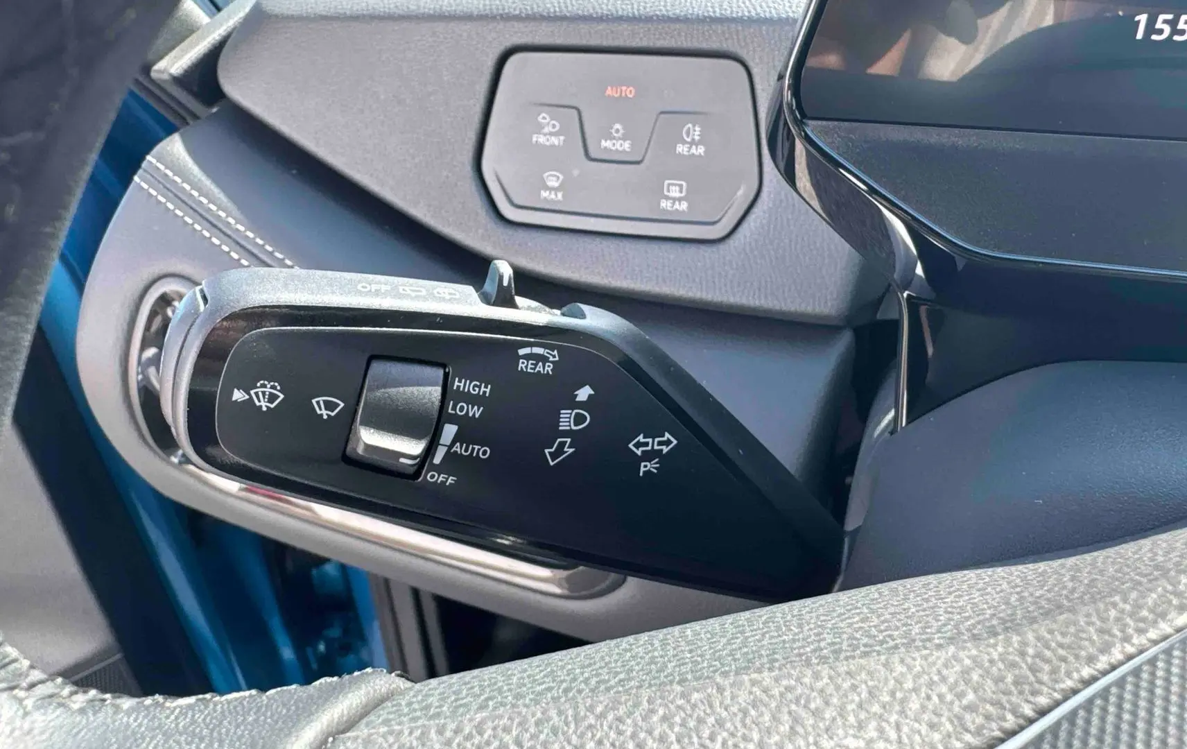 Détail du commodo d'éclairage et essuie-glace d'un Volkswagen ID.3 bleu, intérieur côté conducteur.
