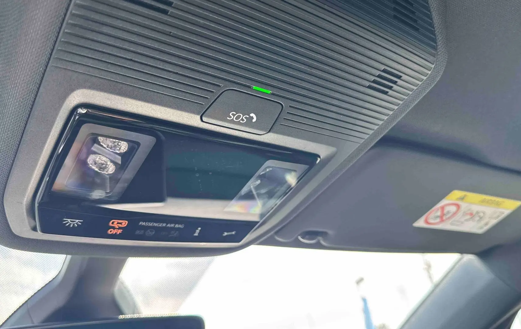 Plafonnier intérieur avec bouton SOS et indicateur airbag passager désactivé dans un Volkswagen ID.3 bleu.