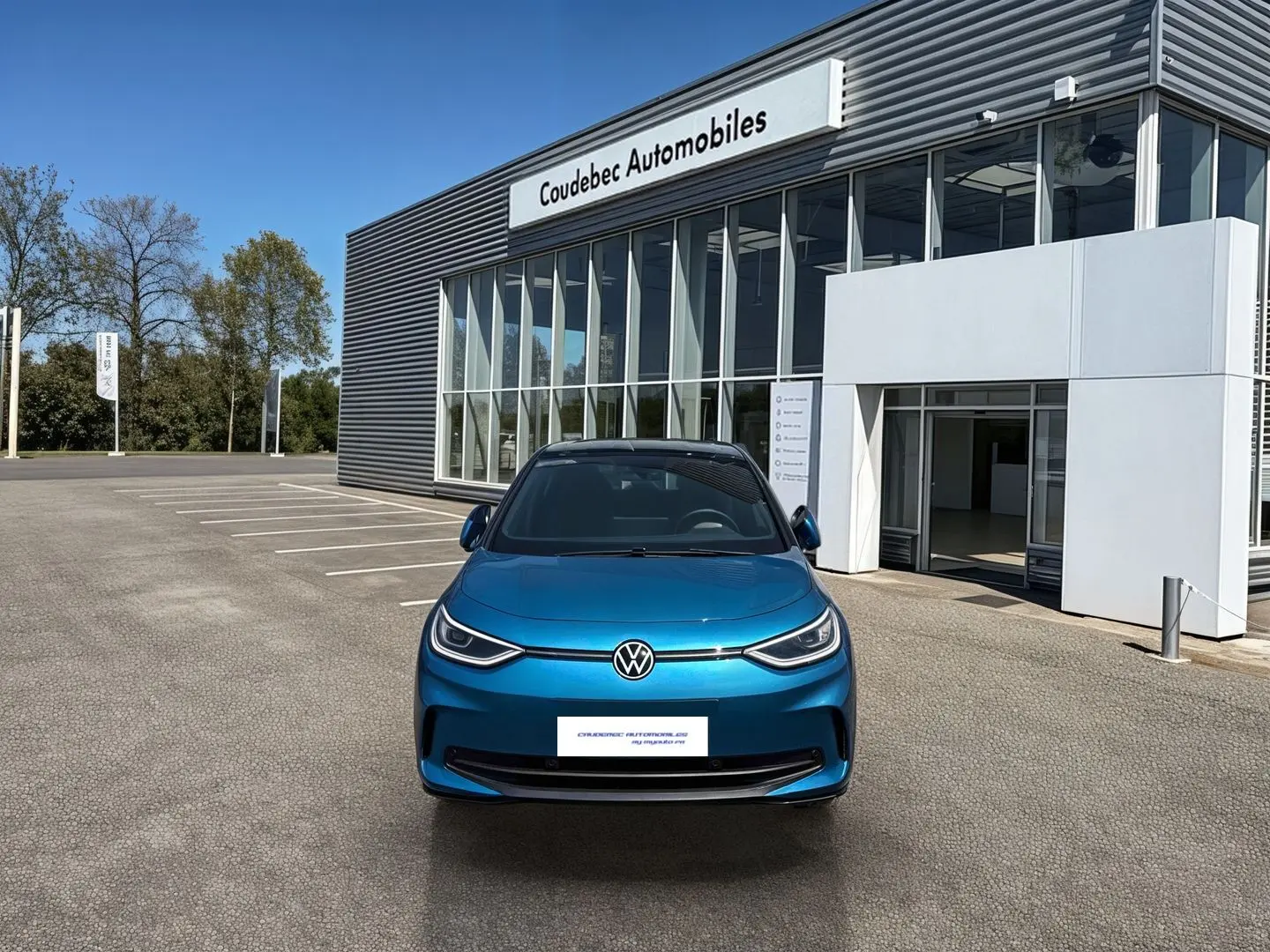 Vue avant d'une Volkswagen ID.3 204 ch Pro S 77 kWh bleu métallisé avec toit noir, devant un concessionnaire.