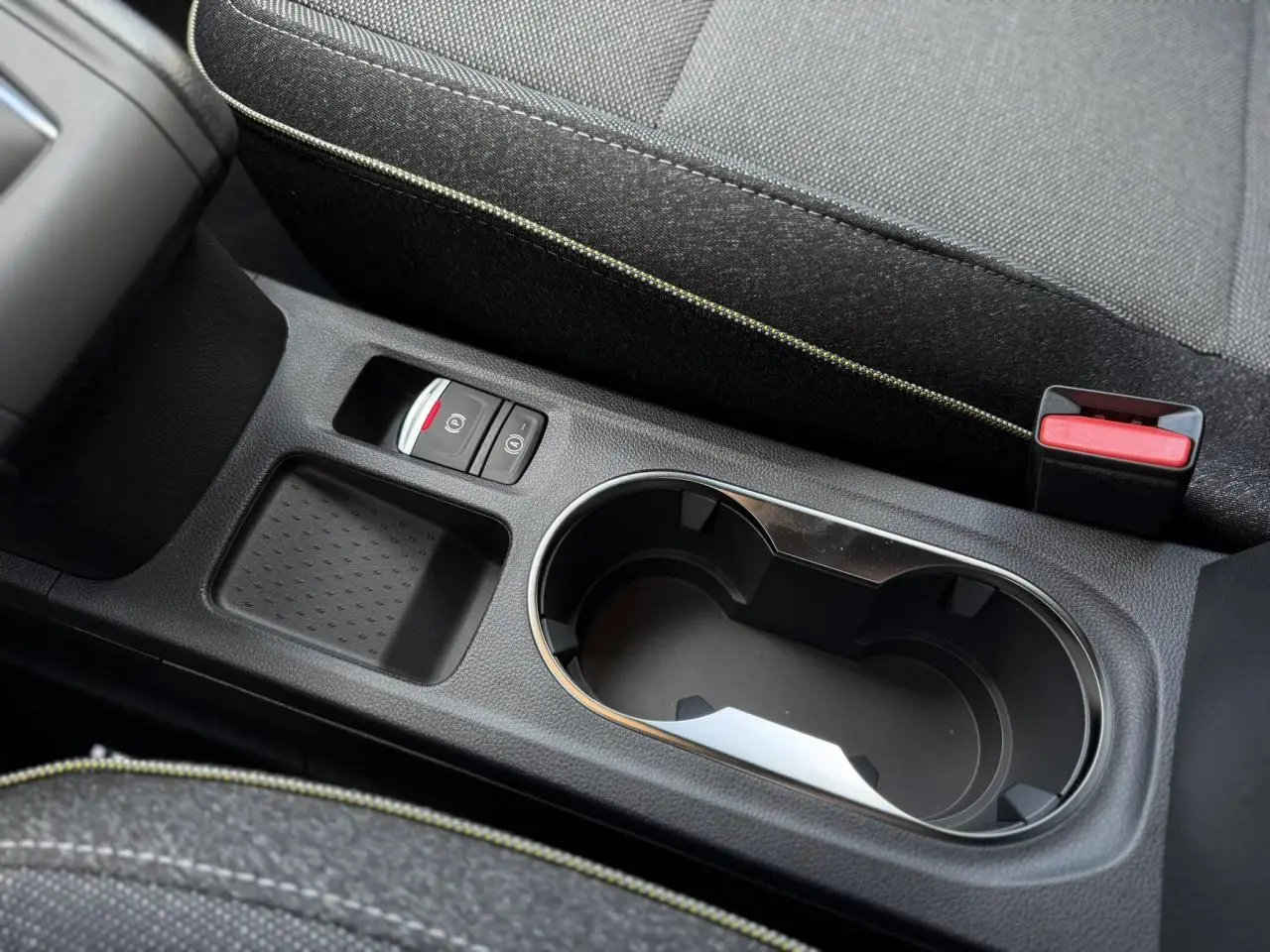 Gros plan sur la console centrale noire avec porte-gobelet, frein à main électrique et accoudoir du Renault Captur 2026.
