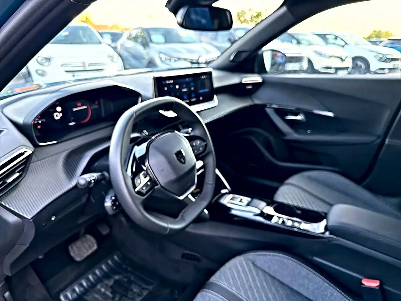 Intérieur Peugeot 2008 1.2 hybrid 145 allure e-dcs6 vu côté conducteur, volant compact et écran tactile central.