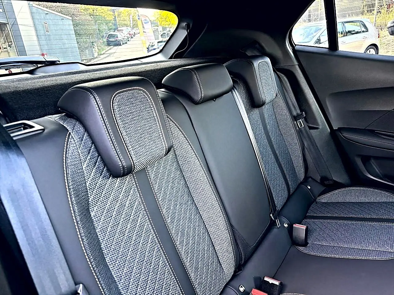 Vue intérieure côté droit des sièges arrière en tissu gris embossé du Peugeot 2008 1.2 hybrid 145 allure 2026.