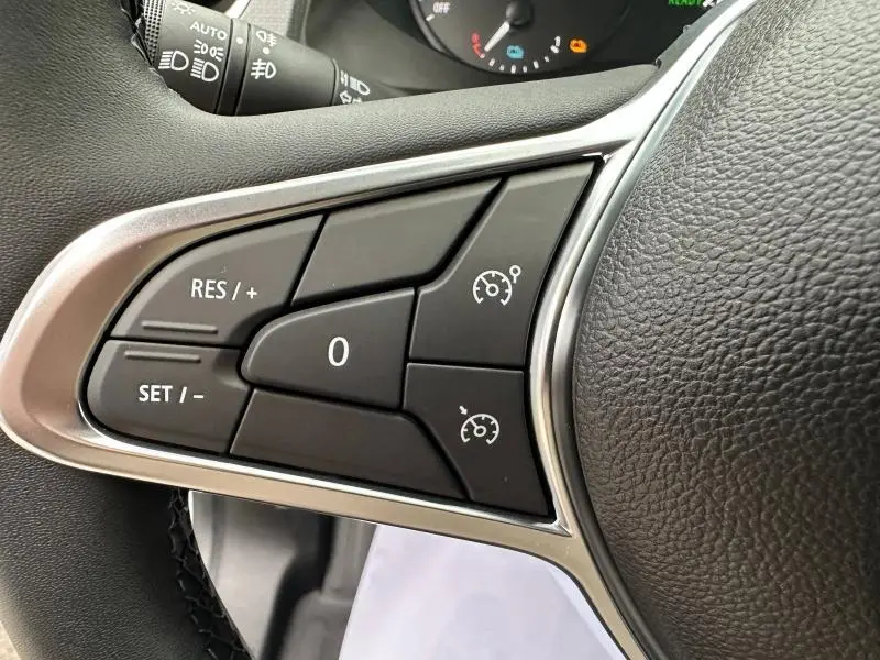 Gros plan sur les commandes de régulateur de vitesse au volant cuir du Nissan Townstar blanc minéral 2024.