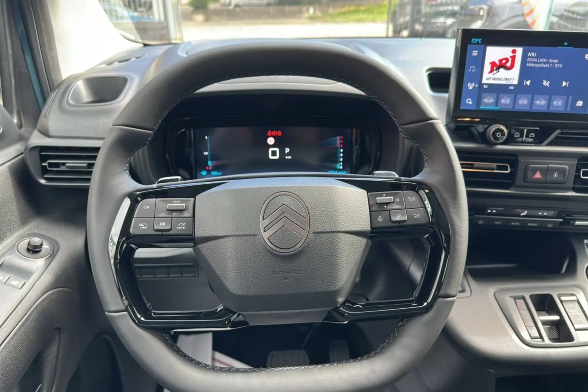 Vue intérieure centrée sur le volant du Citroën Berlingo 2025 Kiama blue, avec tableau de bord numérique et écran tactile.