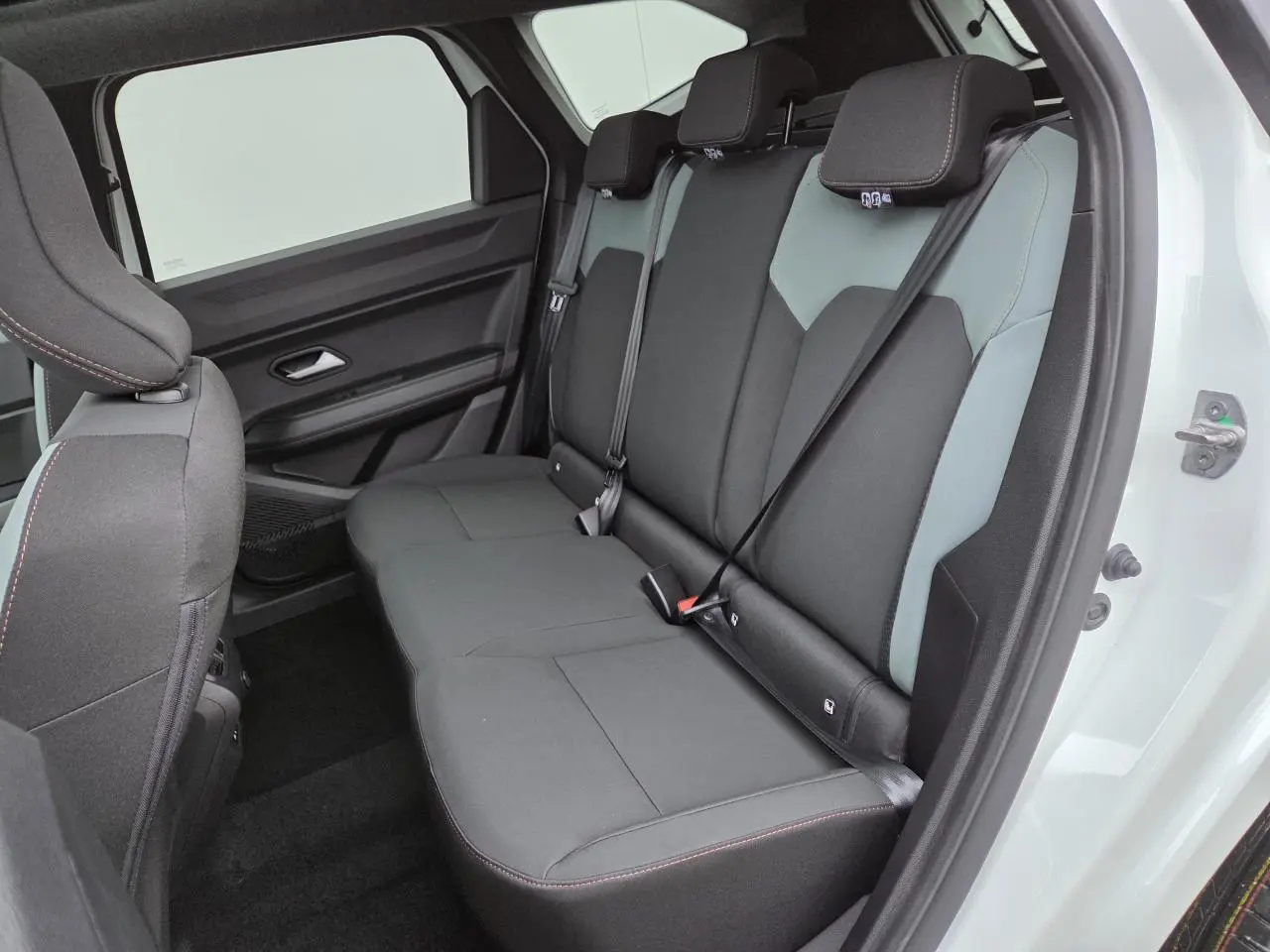 Vue intérieure côté droit sur la banquette arrière noire et grise du Dacia Bigster Blanc Glacier 2025 avec ceinture attachée.