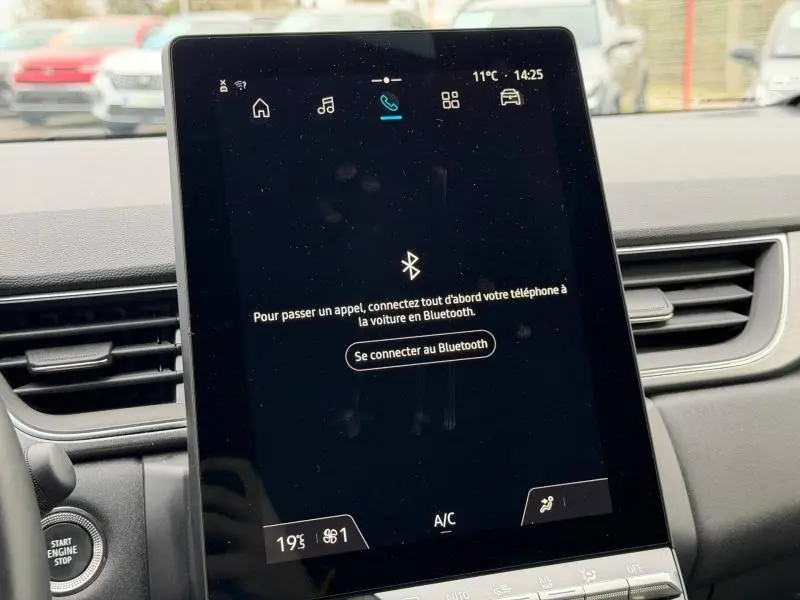 Écran tactile central du Renault Captur 2025 rouge, affichant le menu de connexion Bluetooth, vue intérieure frontale.