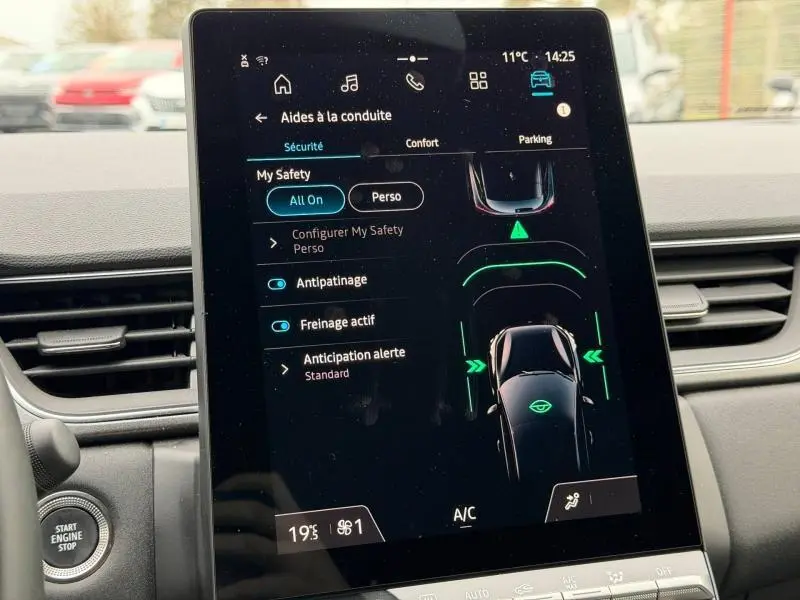 Écran tactile central du Renault Captur 2025 affichant les aides à la conduite, intérieur avec tableau de bord gris.