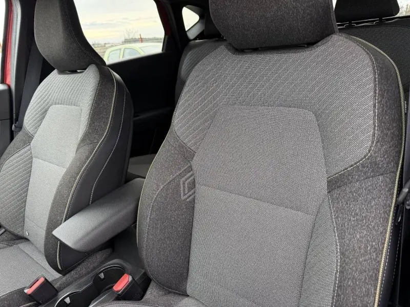 Gros plan sur les sièges avant gris du Renault Captur 2025 Rouge Flamme, mettant en valeur les textures et coutures fines.