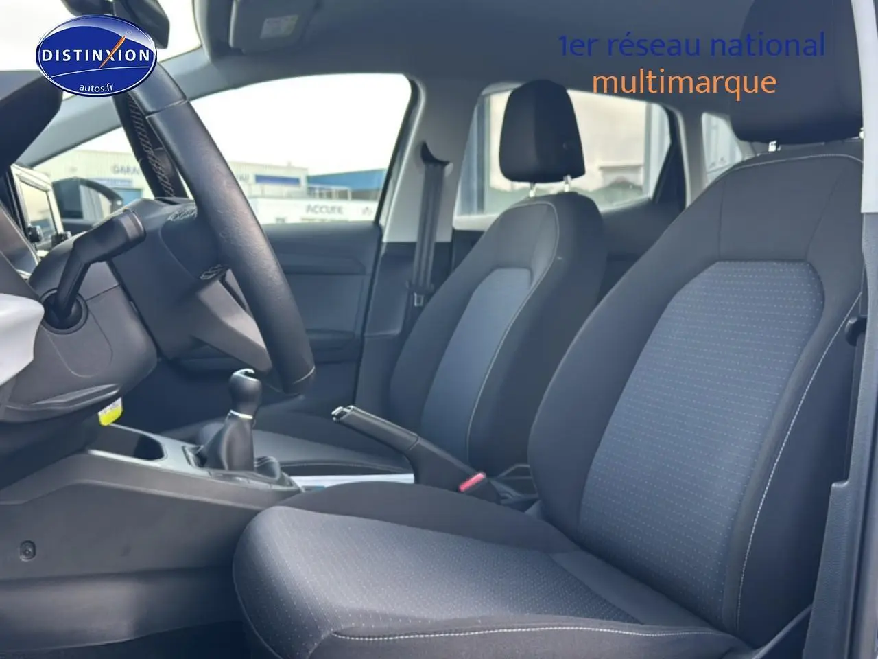 Vue intérieure côté conducteur de la SEAT Ibiza 1.0 TSI 95 Copa avec sièges tissu gris et volant cuir méplat.