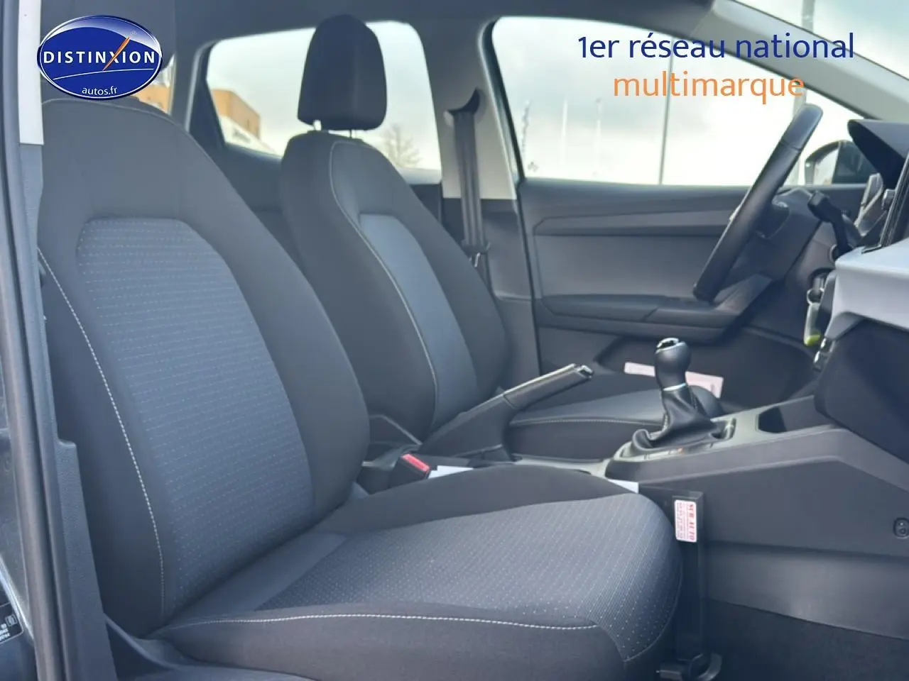 Vue intérieure côté conducteur de la SEAT Ibiza 1.0 TSI 95 Copa avec sièges tissu gris et volant multifonction.