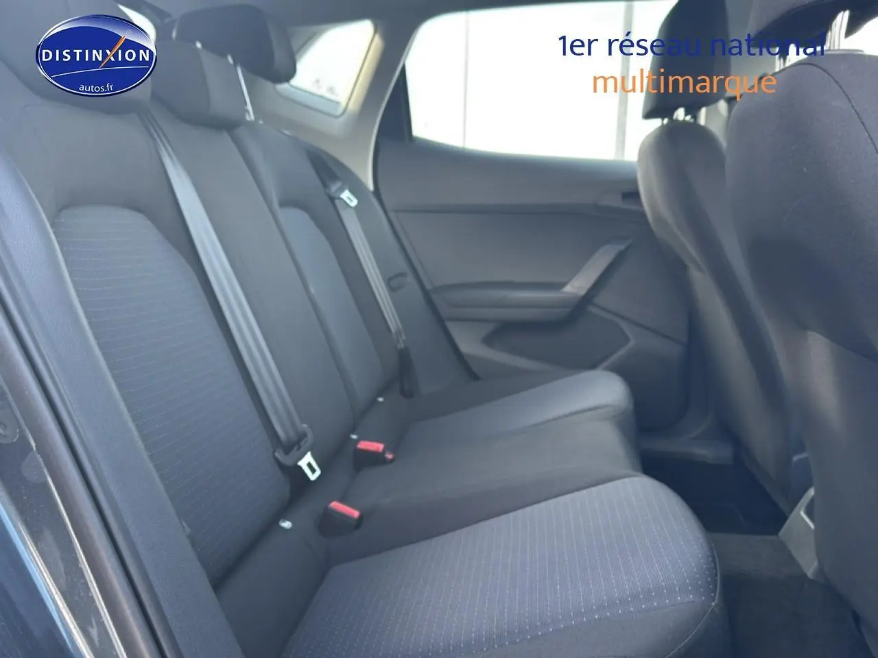 Vue latérale droite de la banquette arrière en tissu gris de la SEAT Ibiza 2025, avec trois appuie-têtes et ceintures visibles.