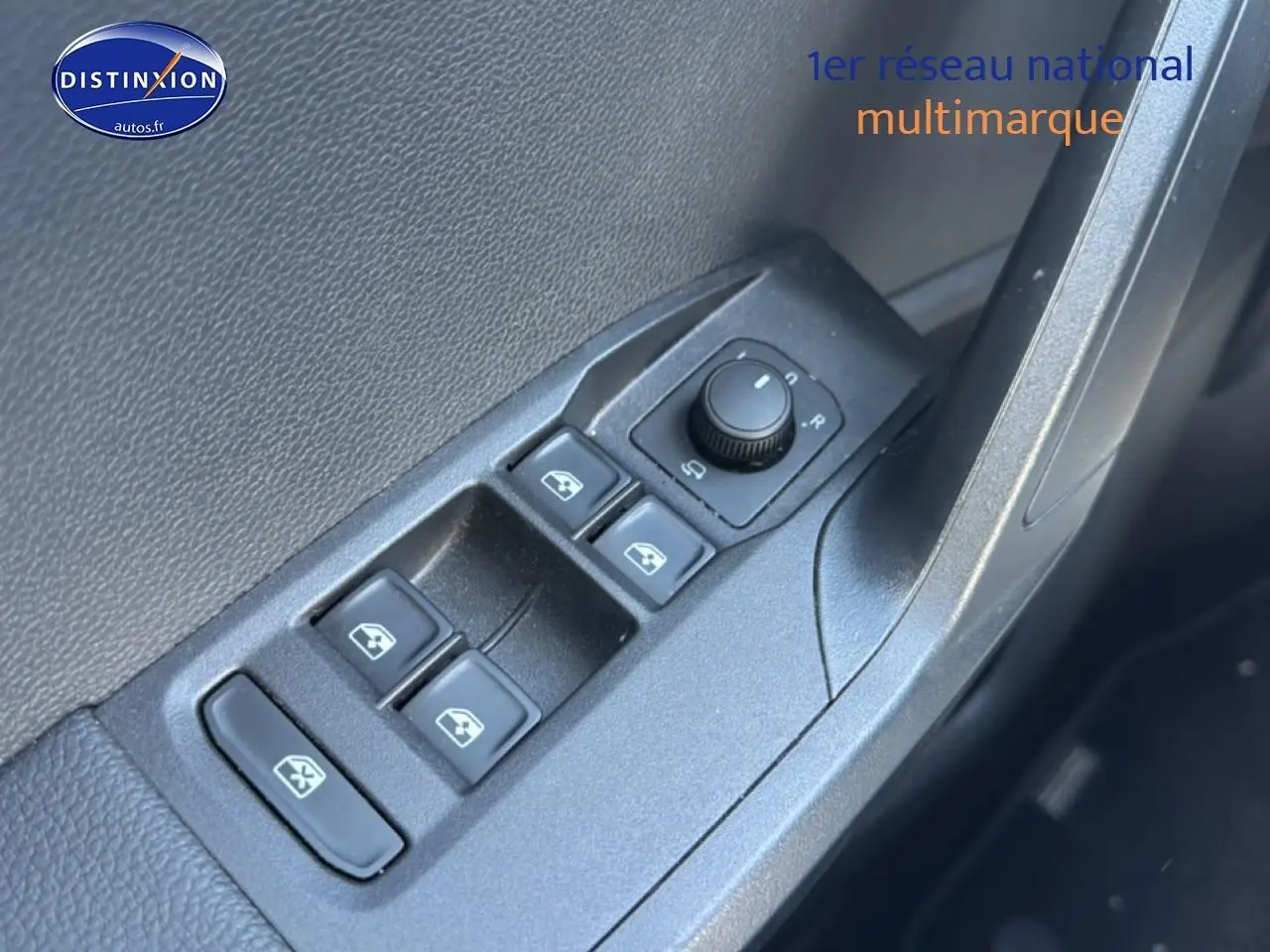 Gros plan sur les commandes de lève-vitres et réglage des rétroviseurs côté conducteur d'une SEAT Ibiza gris magnétique.