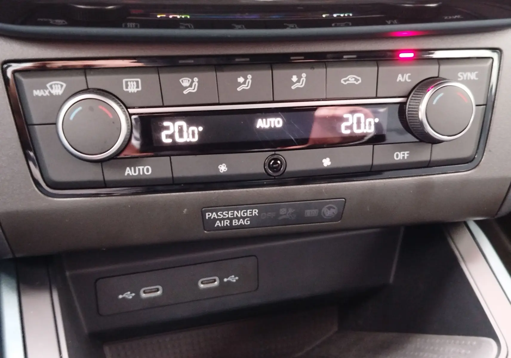 Gros plan sur la console centrale du SEAT Arona 2023, affichant la climatisation automatique réglée à 20°C.