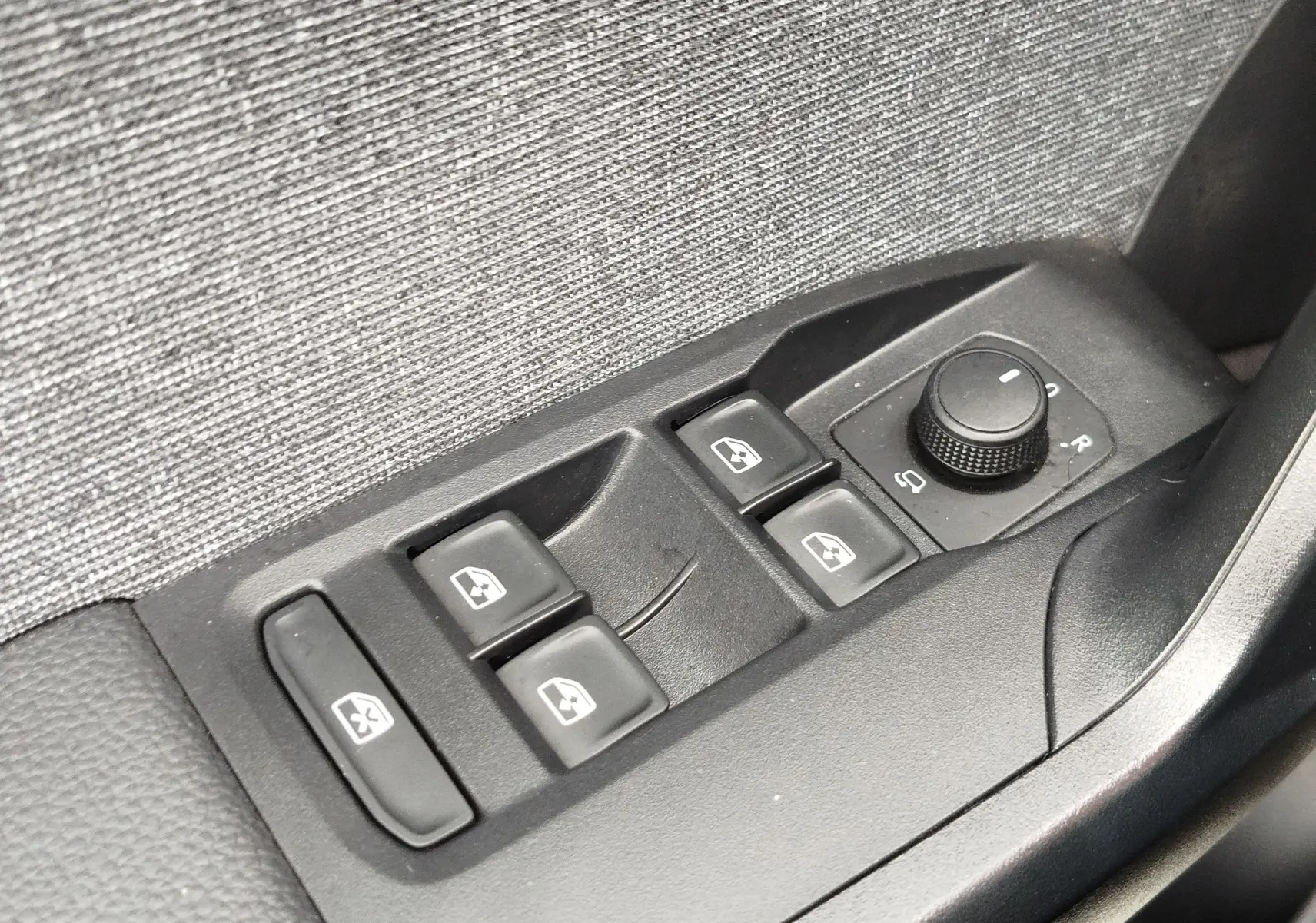 Panneau de commandes des vitres électriques et réglage des rétroviseurs dans une SEAT Arona blanc Candy 2023.