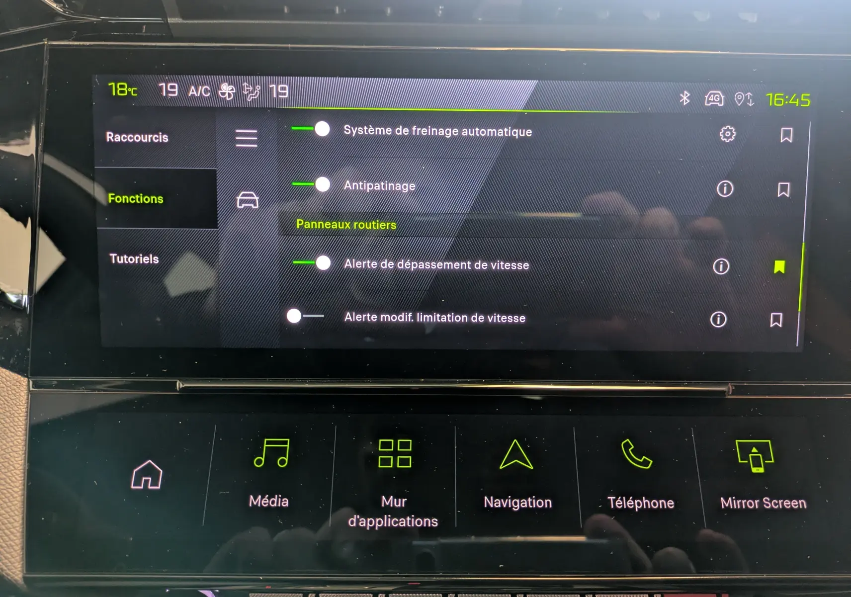 Écran tactile intérieur du Peugeot 308 gris Selenium, affichant les réglages d’aides à la conduite et fonctions multimédia.