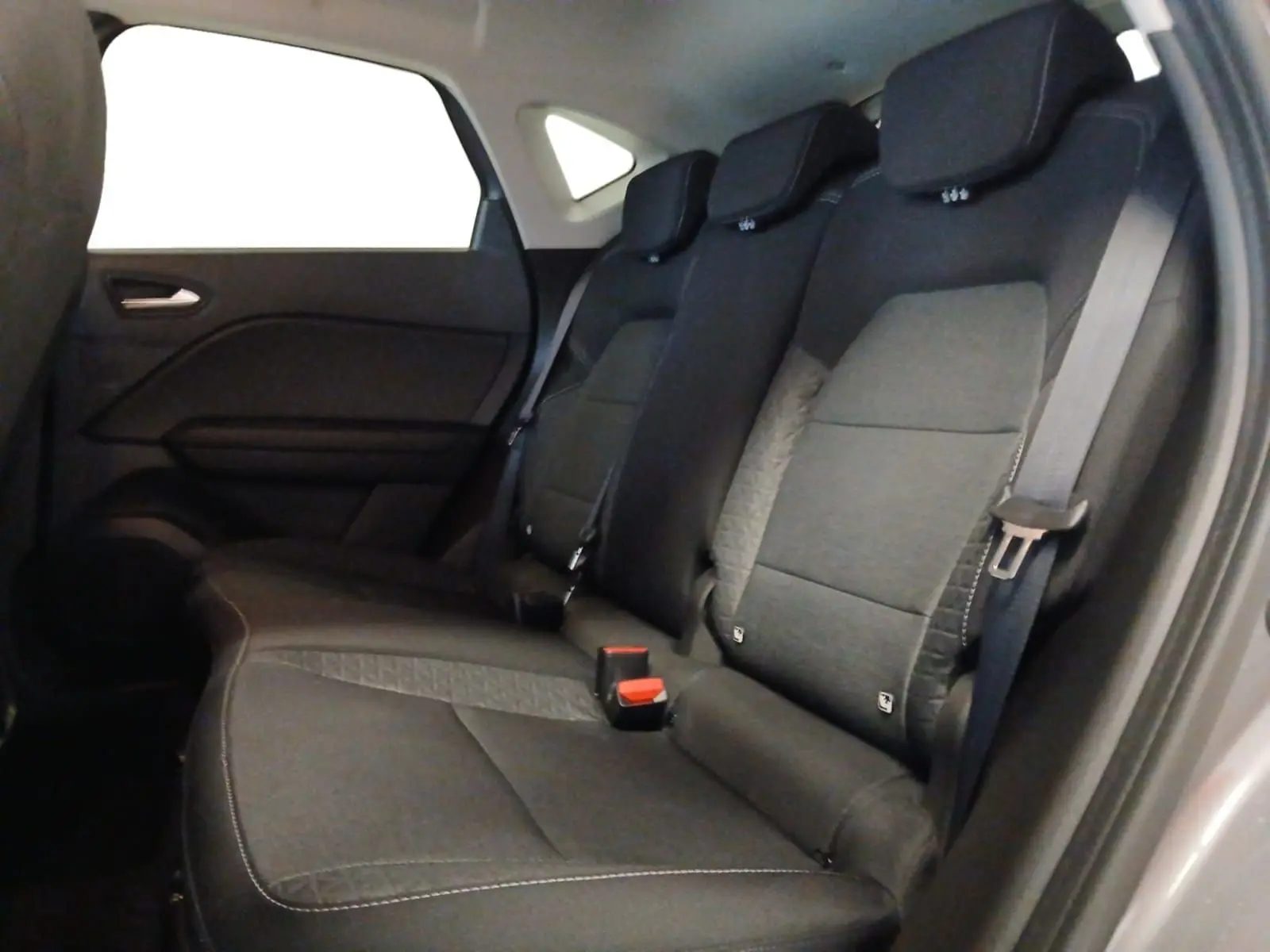 Vue intérieure des sièges arrière noirs du Renault Captur E-Tech Full Hybrid 145 Evolution 2023, avec ceintures de sécurité visibles.