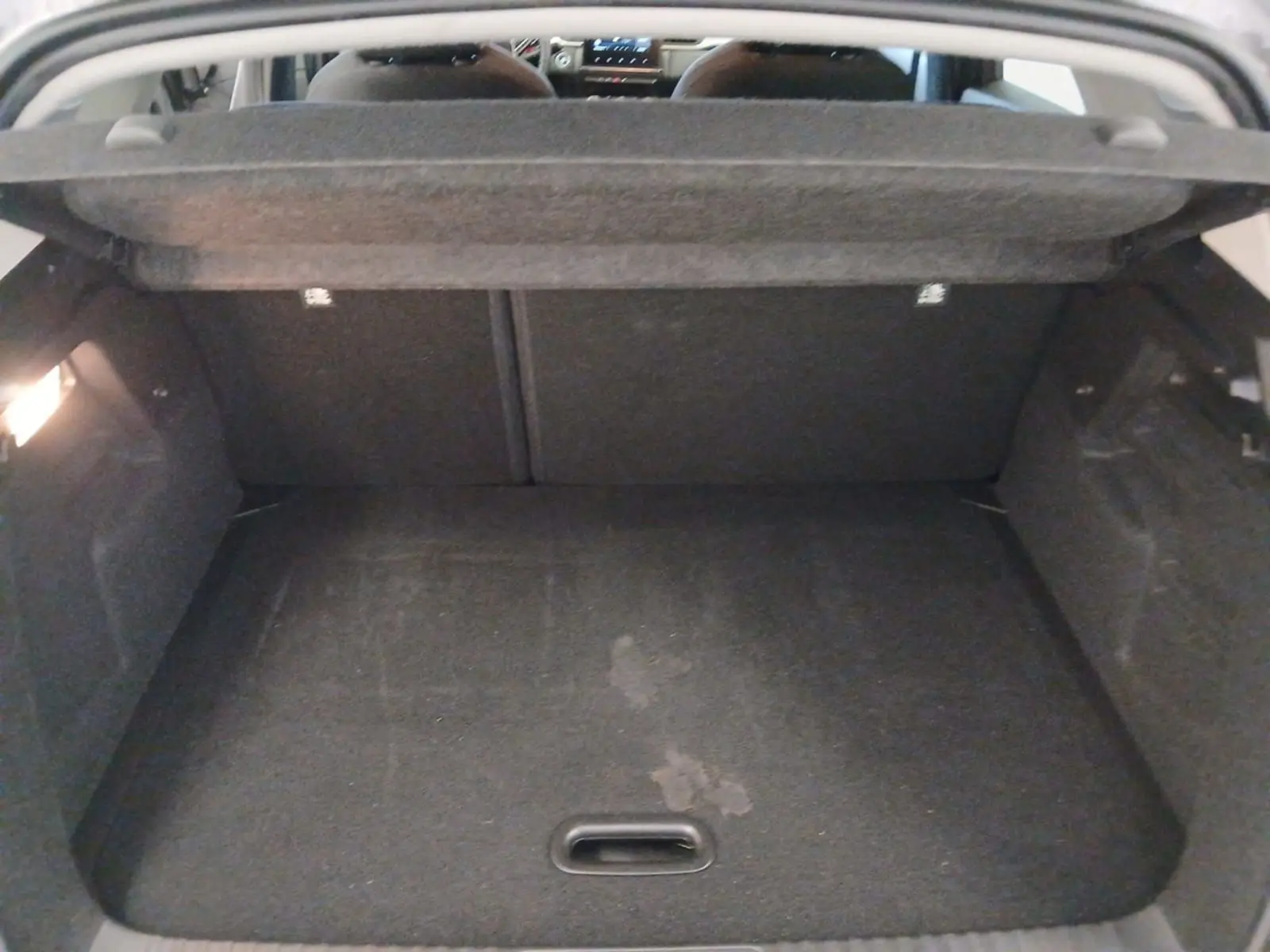 Coffre ouvert vu de l'intérieur d’un Renault Captur E-Tech gris Cassiopée, montrant l’espace de chargement vide.