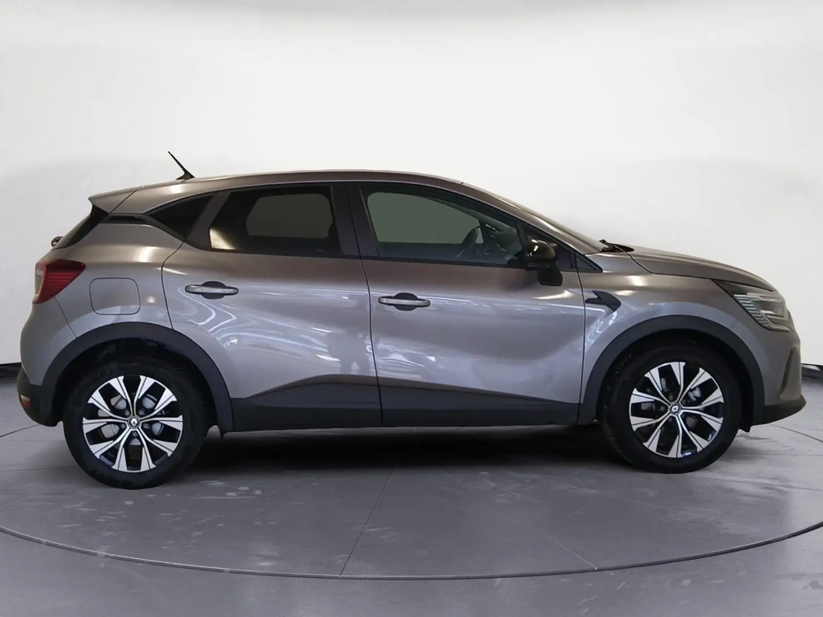 Profil droit du Renault Captur 2023 gris Cassiopée hybride avec jantes alliage distinctives.
