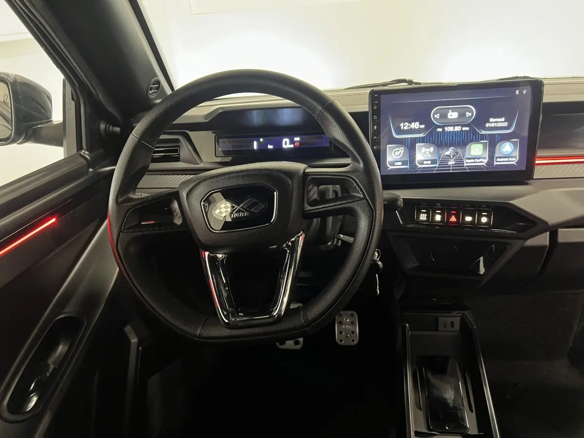 Vue intérieure centrée sur le volant noir et le tableau de bord avec écran tactile du Ligier JS50 Ultimate 2026.