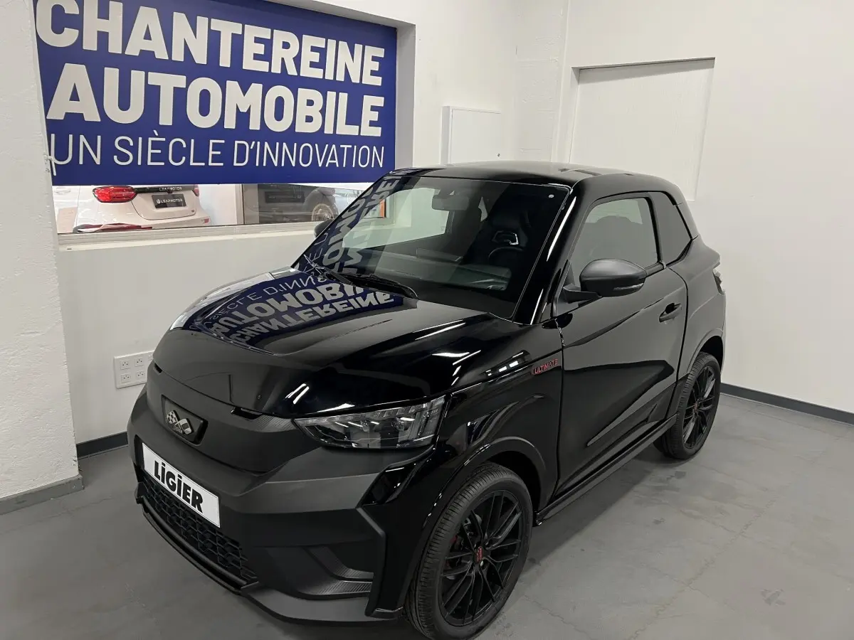 Vue 3/4 avant d'une LIGIER JS50 noire mate avec jantes alu noires et badge Ultimate sur l'aile avant droite.