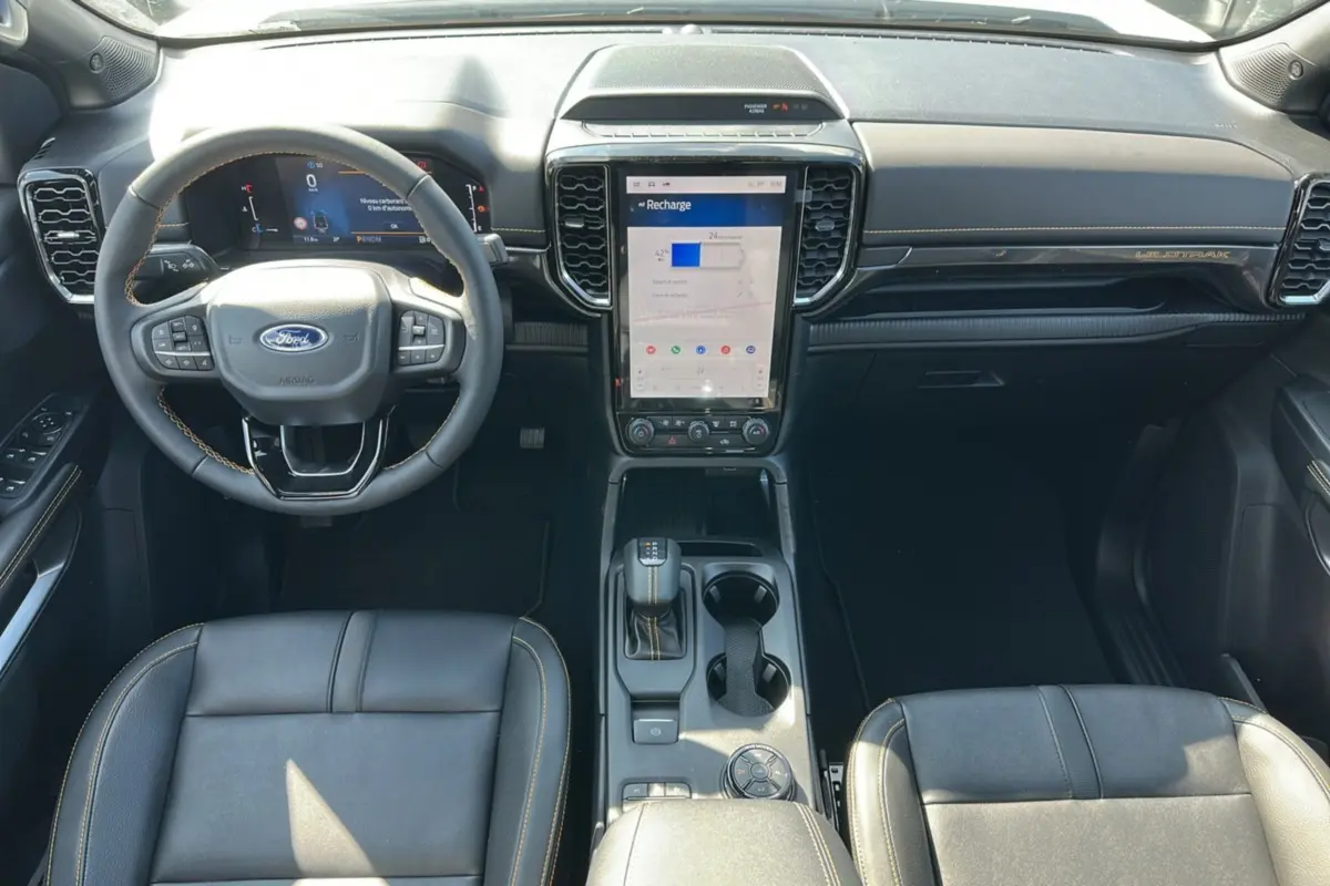 Vue intérieure avant du Ford Ranger Wildtrak blanc 2026, avec volant cuir multifonctions et écran tactile vertical central.