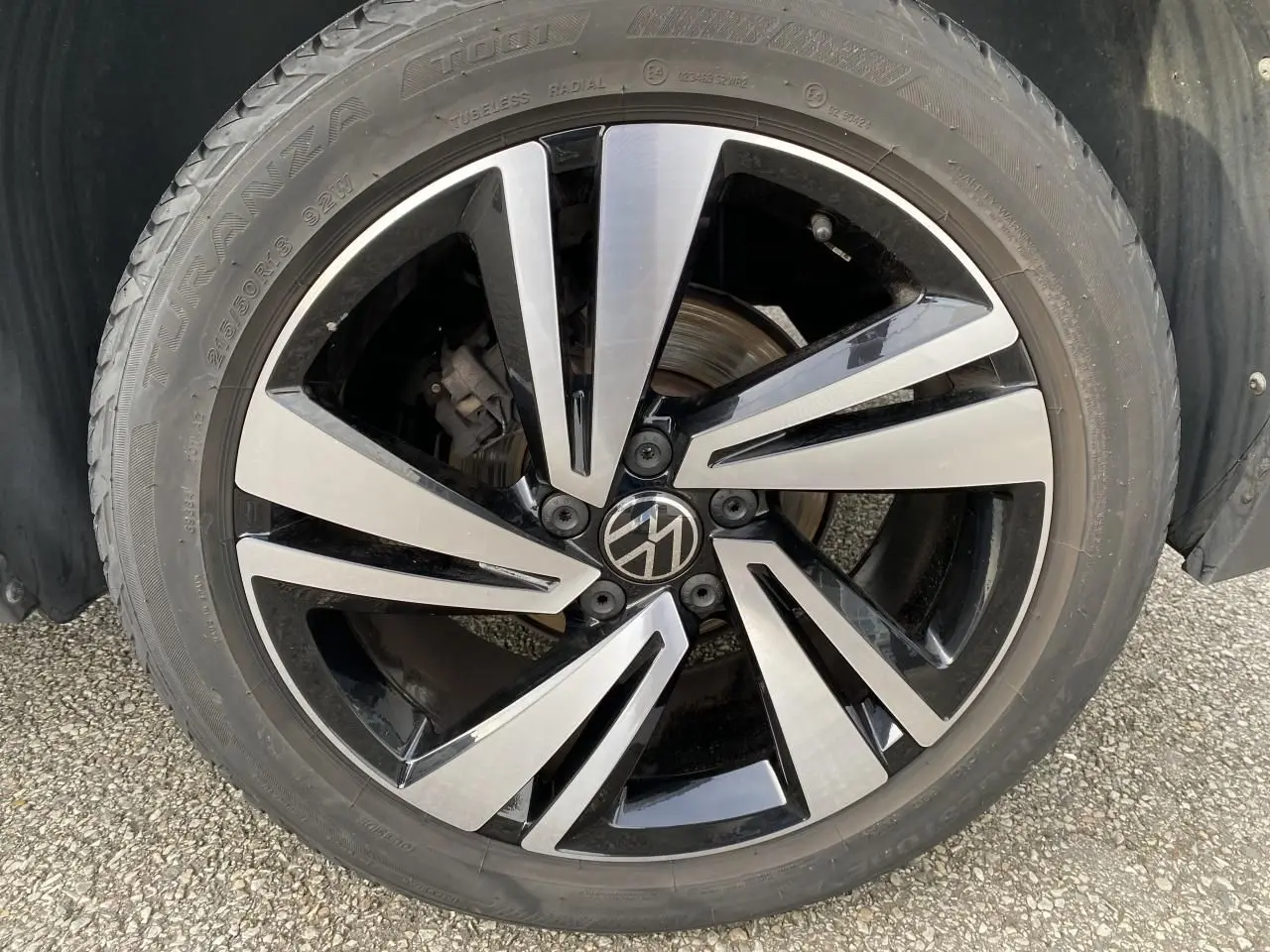Gros plan sur la jante alliage noir et argent Nevada 18 pouces du Volkswagen T-Roc gris, roue avant droite.