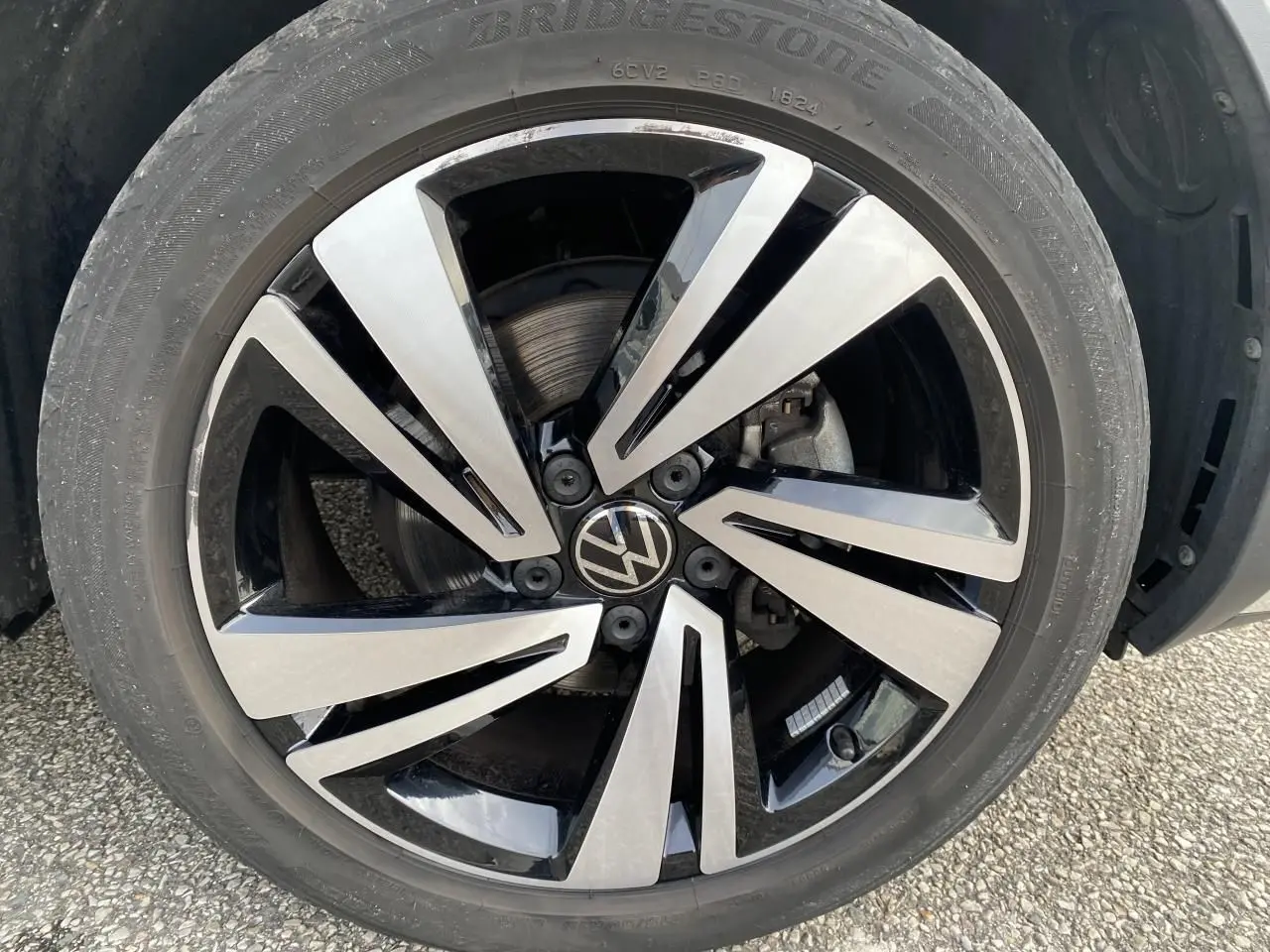 Gros plan sur la jante alliage Nevada noire et argentée du Volkswagen T-Roc 2024, détail du pneu Bridgestone.