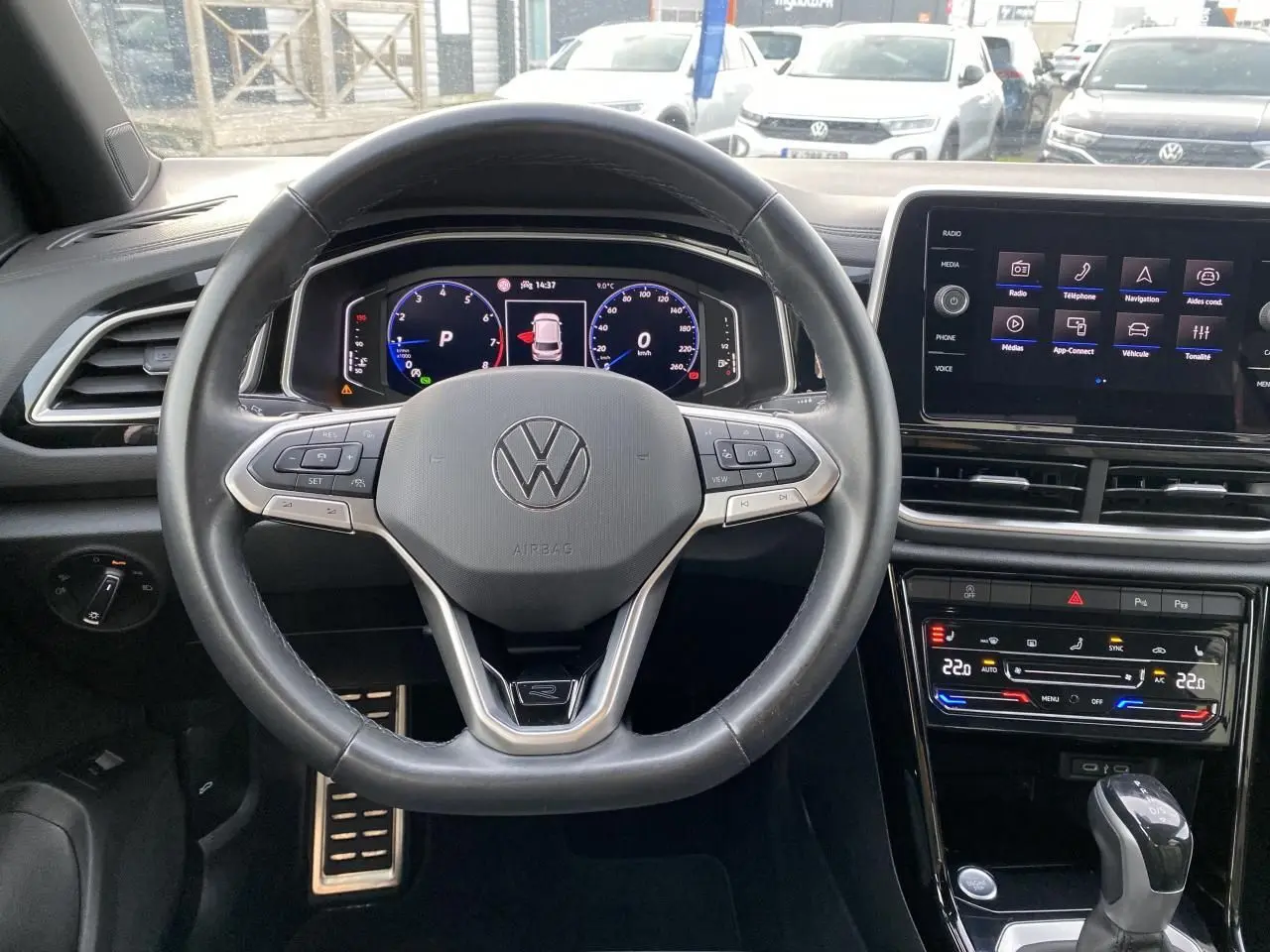 Vue intérieure centrée sur le volant cuir noir et le tableau de bord digital du Volkswagen T-Roc 2024.