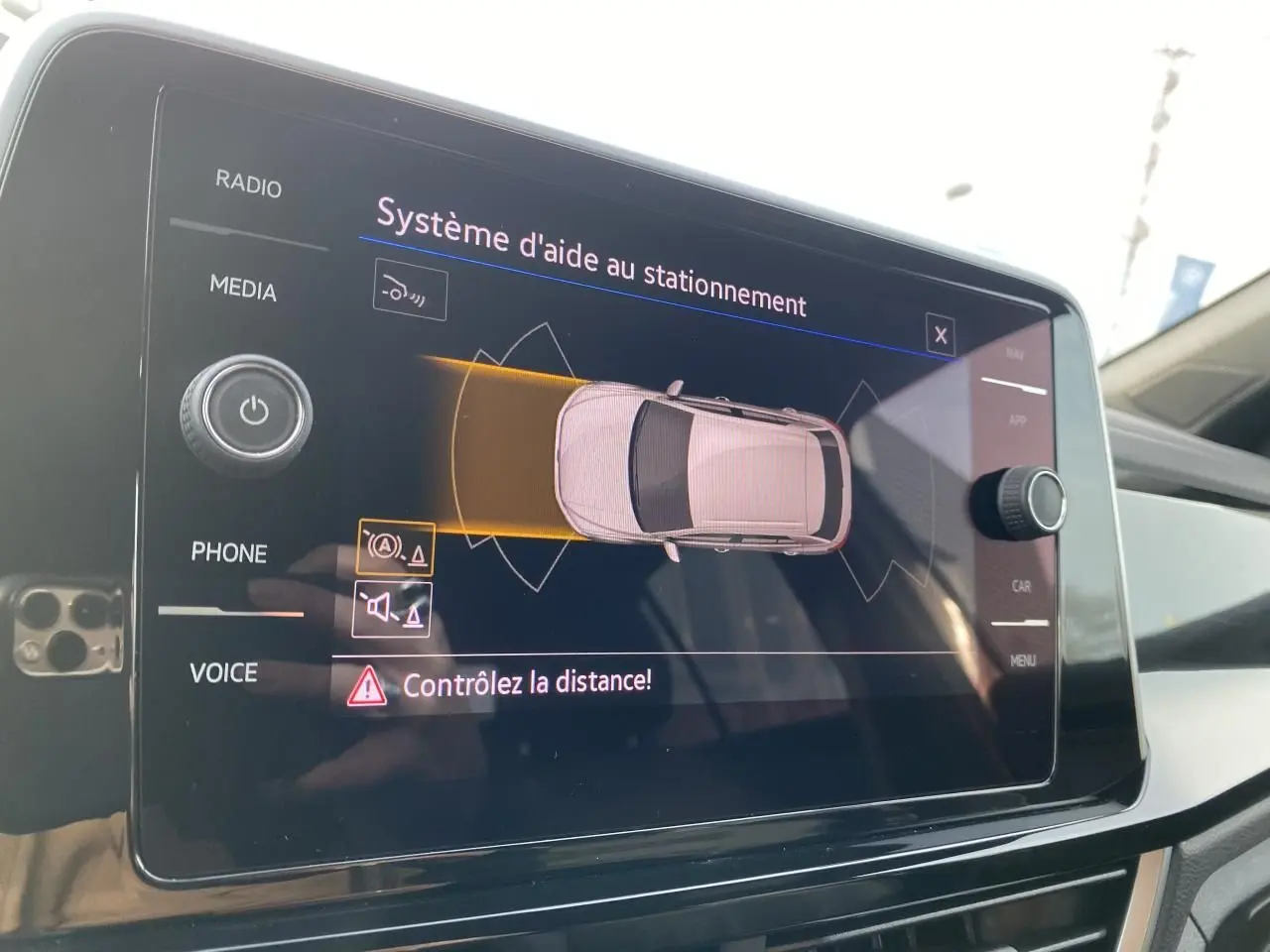 Écran tactile du système d'aide au stationnement dans l'habitacle d'une Volkswagen T-Roc gris, vue intérieure.