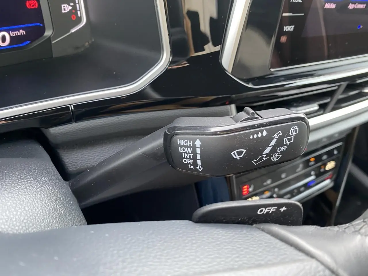 Gros plan sur la commande des essuie-glaces dans l'habitacle noir du Volkswagen T-Roc 2024.