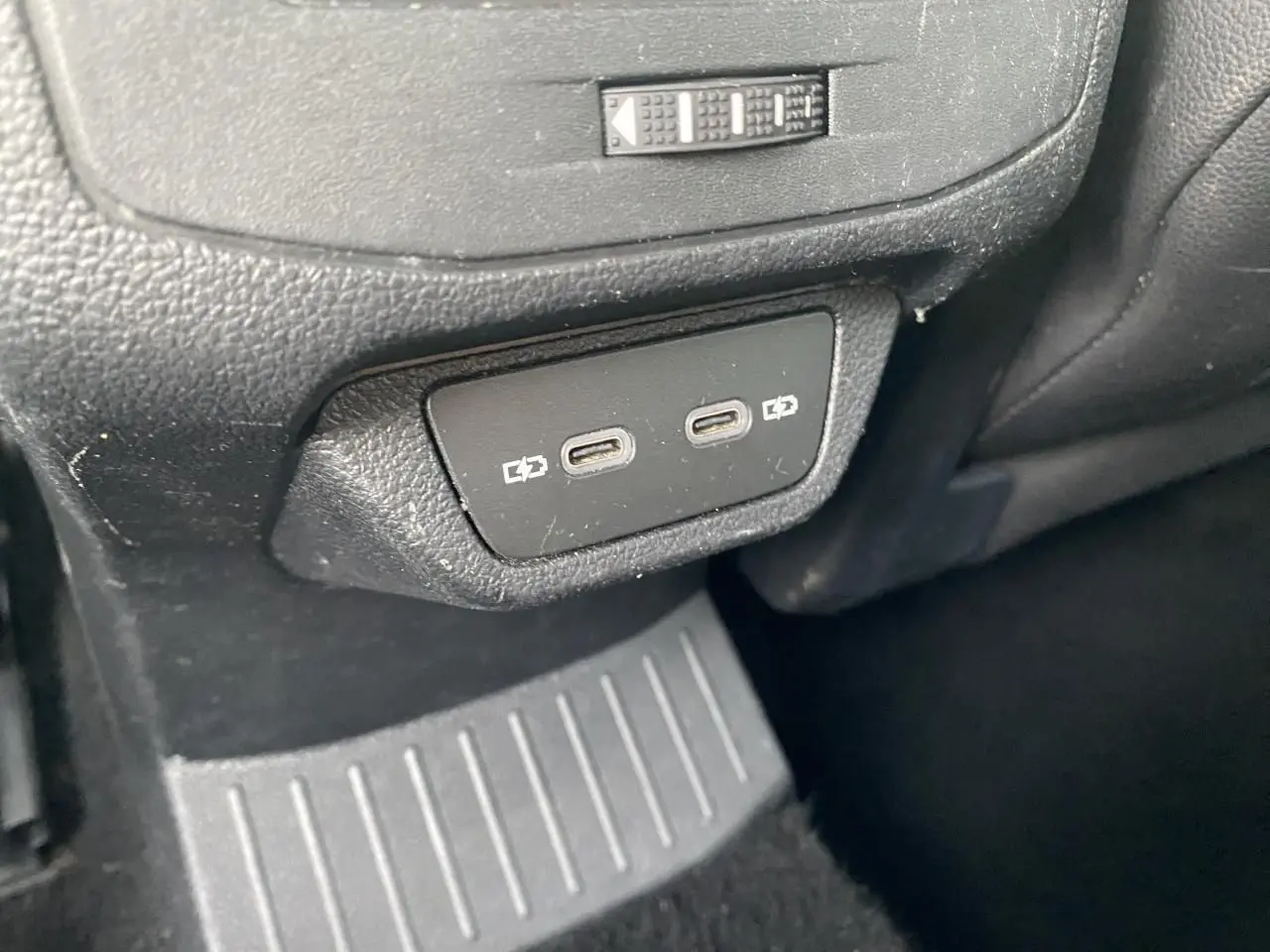 Vue rapprochée des deux ports USB-C de recharge arrière sur la console centrale noire du Volkswagen T-Roc 2024.