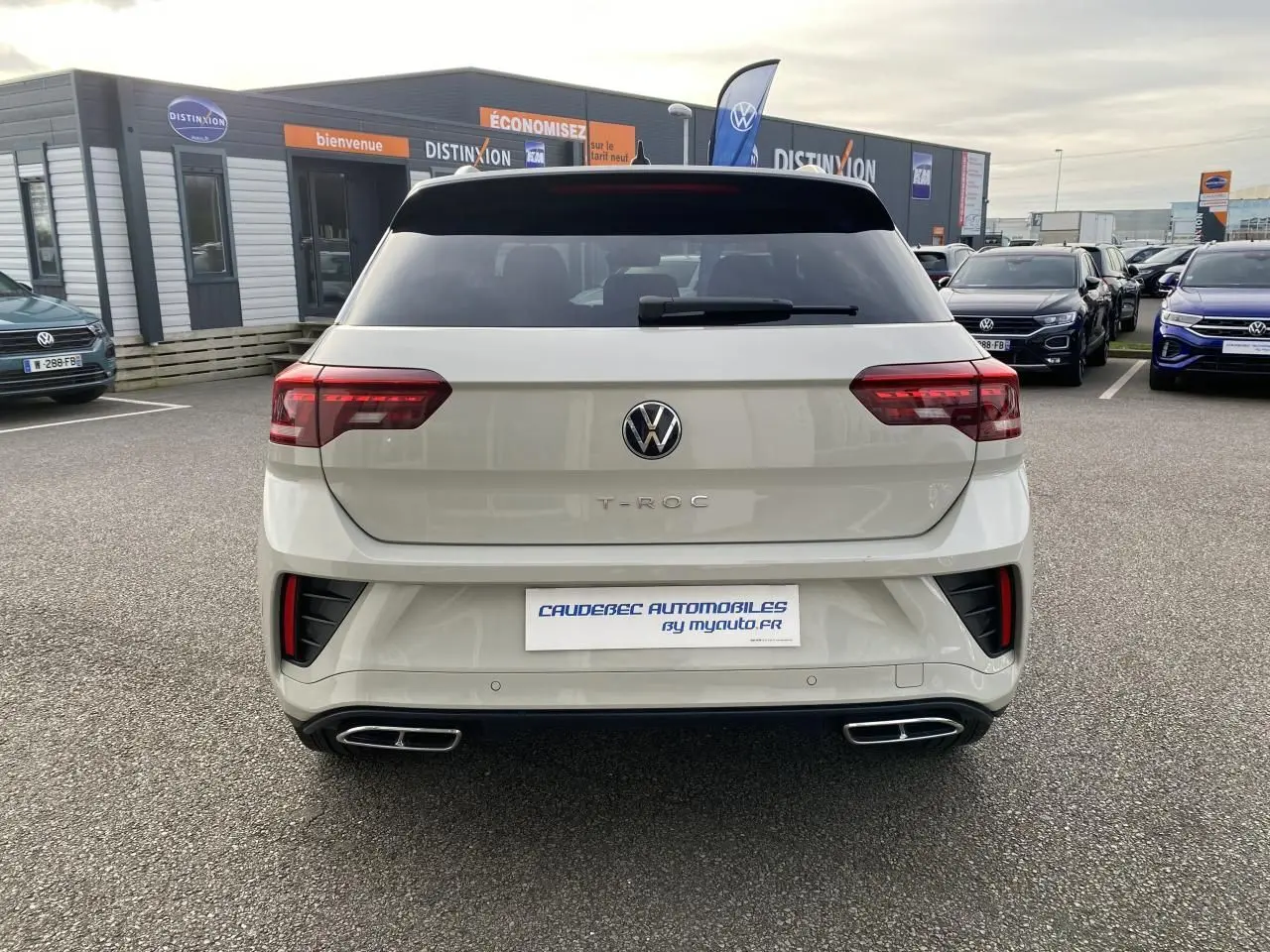 Vue arrière d’un Volkswagen T-Roc gris clair avec feux LED et double sortie d’échappement rectangulaire chromée.