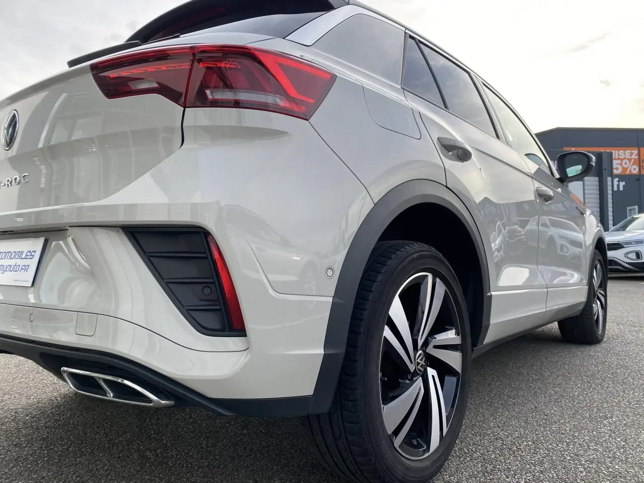 Vue 3/4 arrière droite du Volkswagen T-Roc gris clair avec jantes alliage Nevada noires et feux arrière LED.