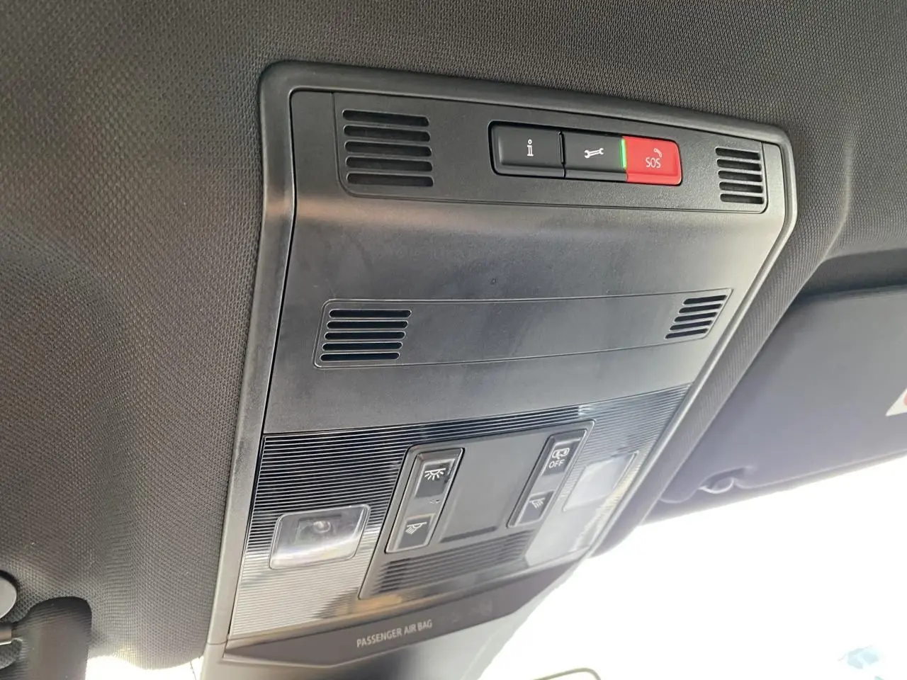 Vue en gros plan du plafonnier intérieur noir du Volkswagen T-Roc 2024 avec boutons SOS et éclairage.