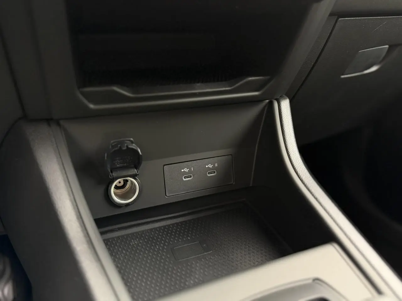 Gros plan sur la console centrale du Renault Captur 2026, montrant prises USB-C, allume-cigare et chargeur induction noir.