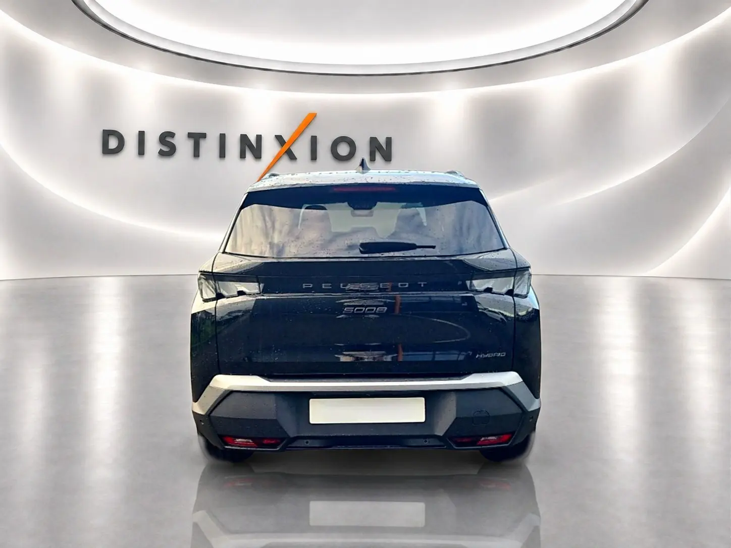 Vue arrière d'un Peugeot 5008 Hybrid 145 GT noir, avec feux arrière LED et hayon électrique dans un showroom lumineux.